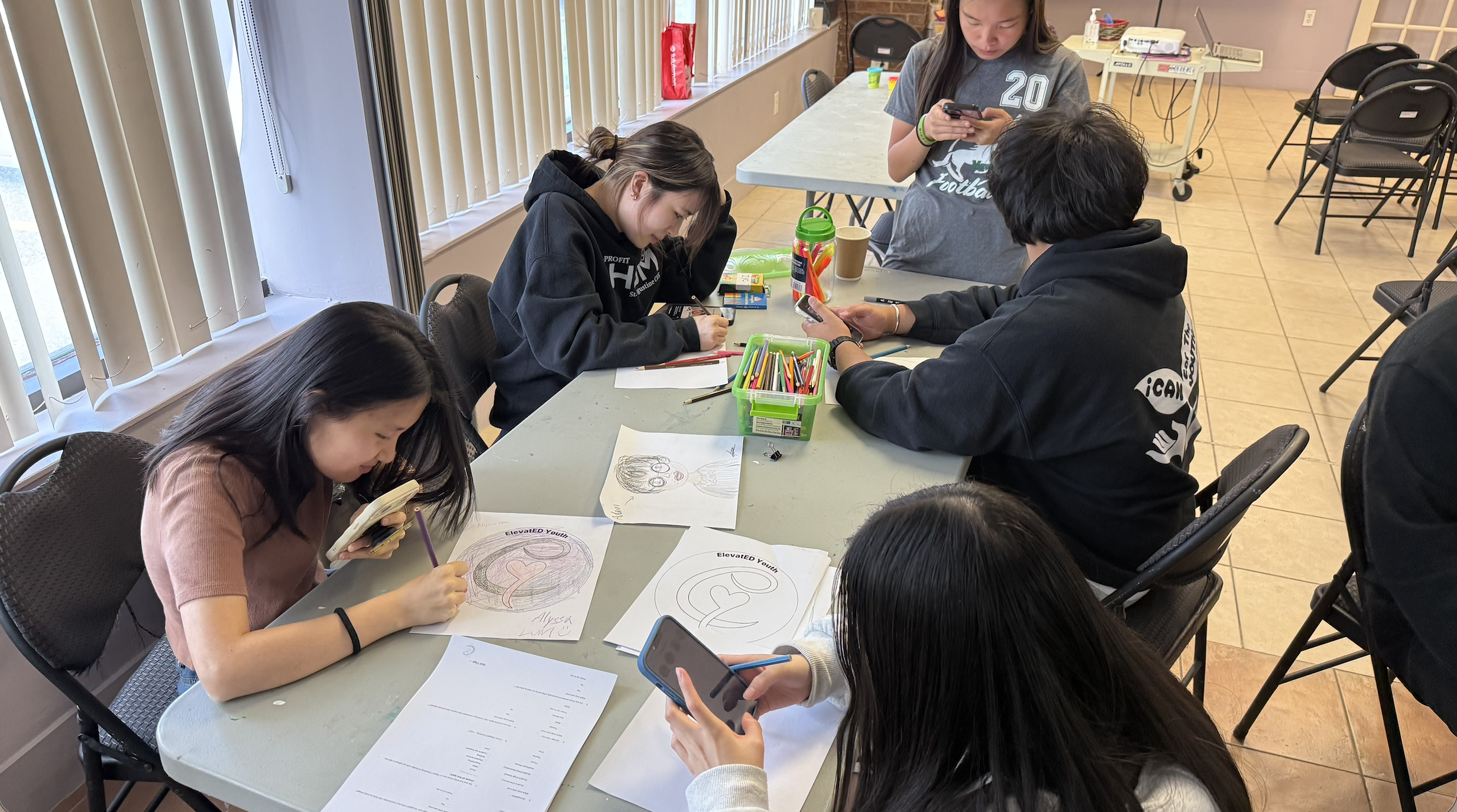 A young person drawing the ElevatED Youth logo
